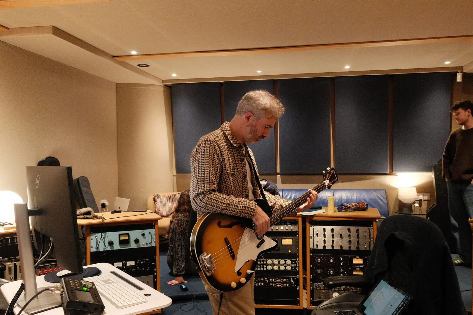 Euan Burton playing bass in the control room at GloWorm Recording